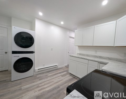 A modern kitchen with white cabinets and a black countertop.