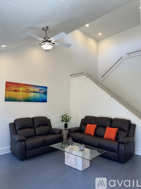 A living room with a black sofa and a black recliner.
