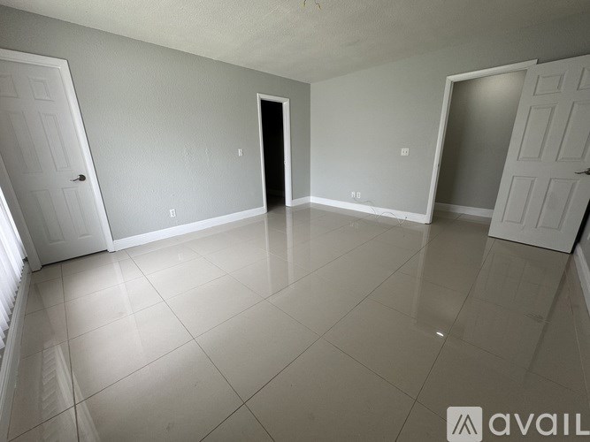 A spacious empty room with white walls and floor.