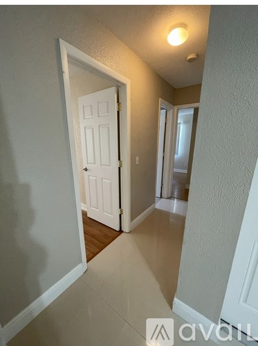 A hallway with a white door and a light on the ceiling.