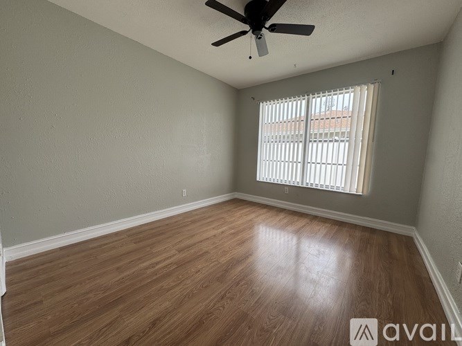 A room with wooden flooring and a ceiling fan.