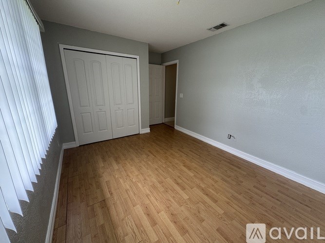A room with wooden flooring and a white door.