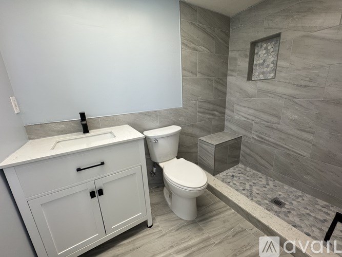 A bathroom with a toilet, sink, and shower.