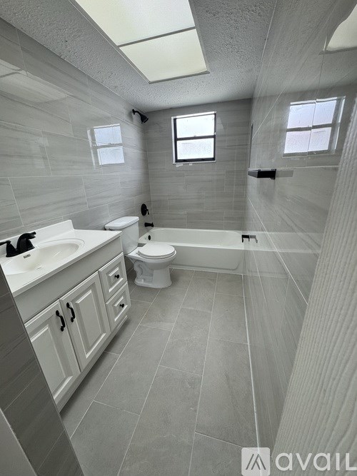 A bathroom with a toilet, sink, and bathtub.
