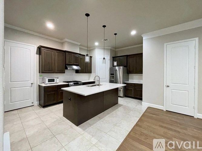 A kitchen with brown cabinets and a white island.