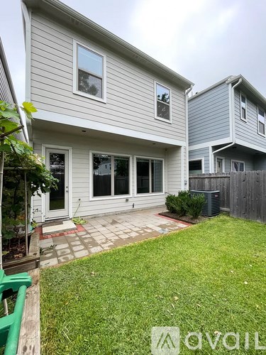 A grey house with a green lawn in front.