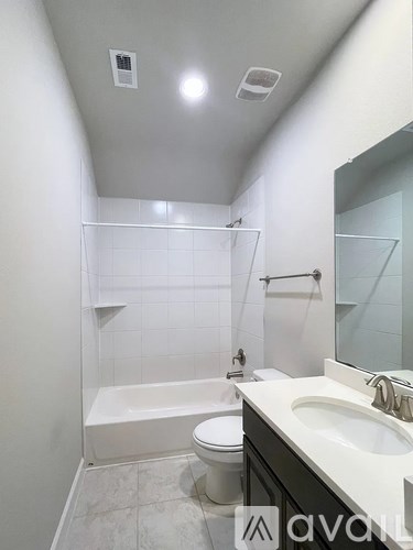 A white bathroom with a toilet, sink, and bathtub.