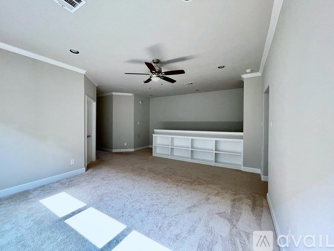 A room with a ceiling fan and a carpeted floor.