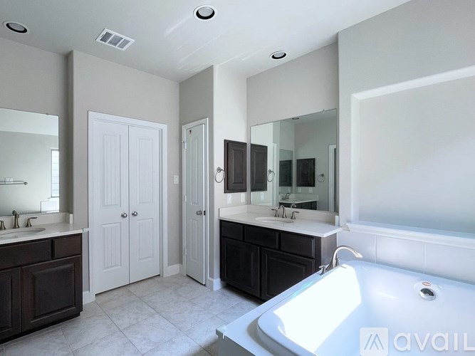 A bathroom with a tub, sink, and mirror.