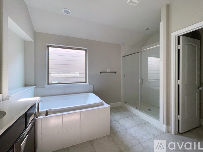 A bathroom with a tub, sink, and shower.