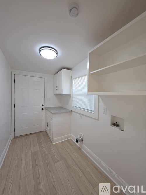 A small, empty room with a door and a window.