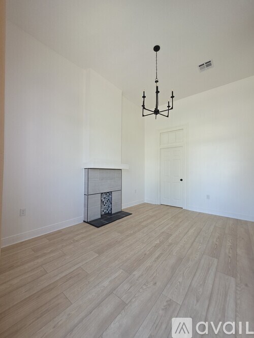 A room with a fireplace and a chandelier.