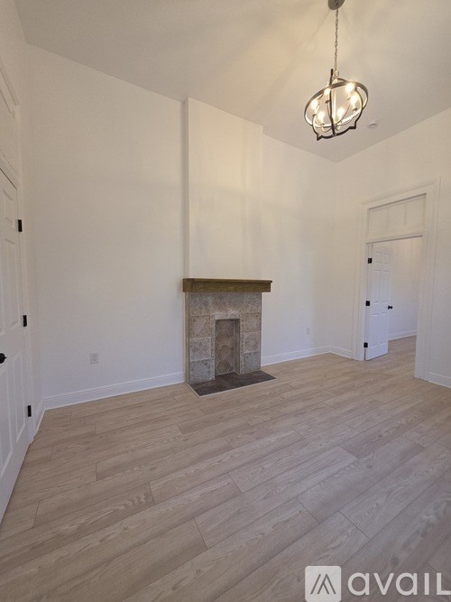 A room with a fireplace and wooden flooring.