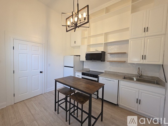 A kitchen with white cabinets and a wooden table.