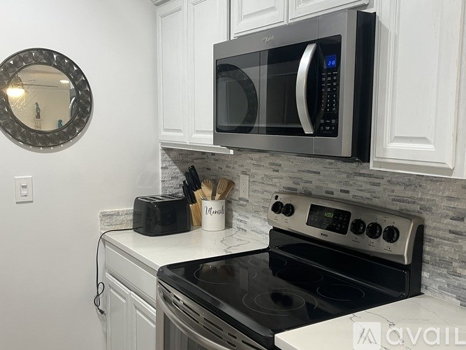 A modern kitchen with a stove, microwave, and oven.