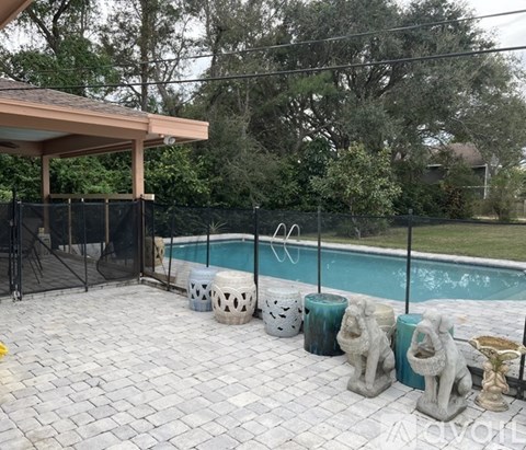 A pool surrounded by statues and a fence.