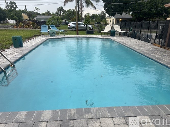 A swimming pool with a blue tiled edge and a grey tiled floor.