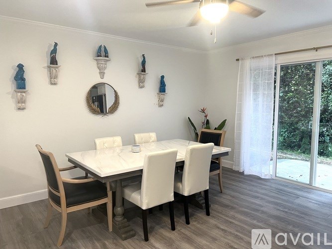 A dining room with a white table and chairs.