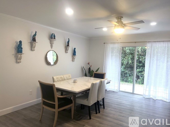 A dining room with a table, chairs, and a ceiling fan.