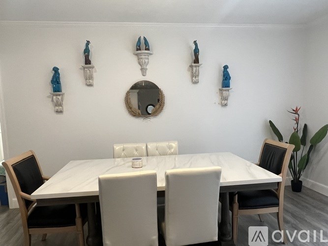 A dining room with a white table and chairs.