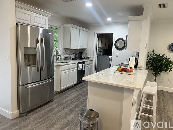 A kitchen with a refrigerator, oven, and sink.