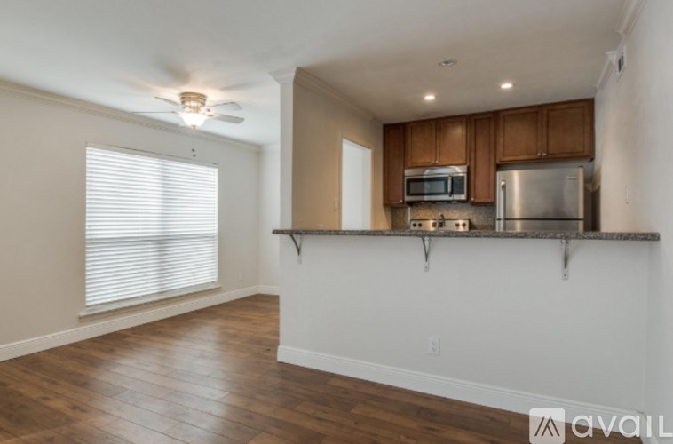 A kitchen with wooden cabinets and a stainless steel refrigerator.