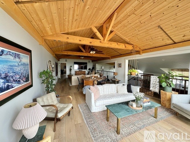 A living room with a wooden ceiling and furniture.