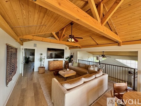 A living room with a tan couch and wooden floors.