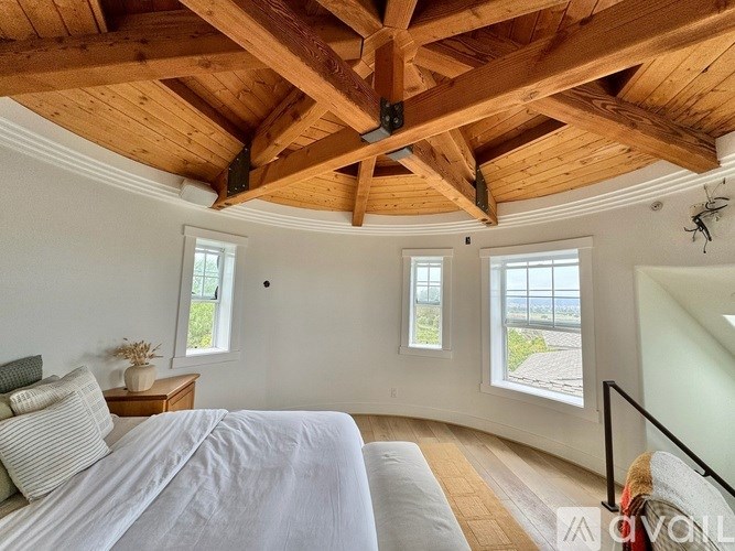 A bedroom with a large bed and a wooden ceiling.