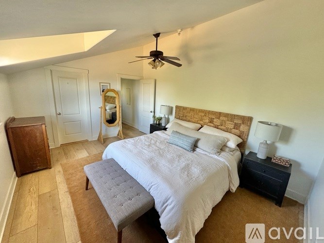 A bedroom with a large bed and a ceiling fan.