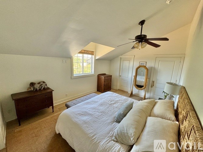 A bedroom with a bed, dresser, and mirror.