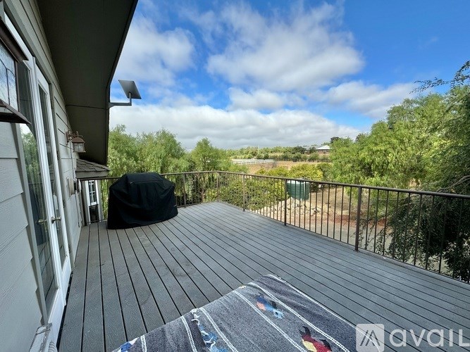 A balcony with a black tarp and a grey rug is shown.