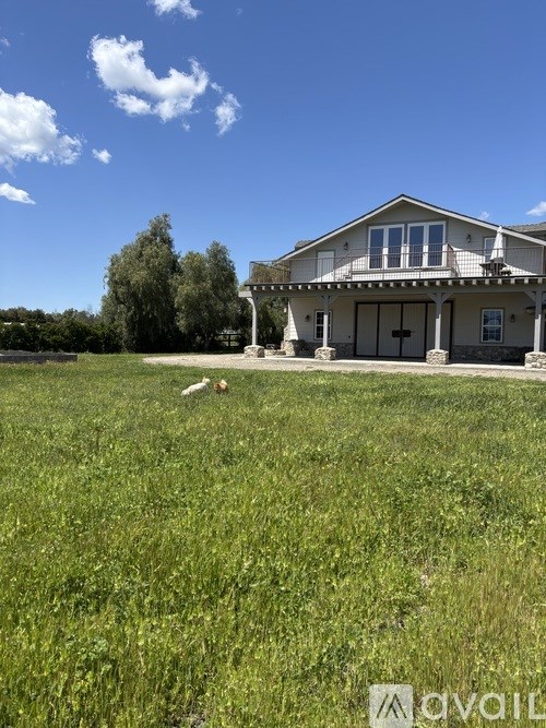A person is lying on the grass in front of a house.