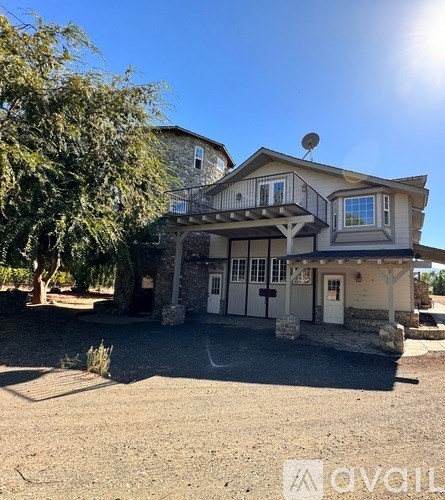 A house with a balcony and a satellite dish on the roof.