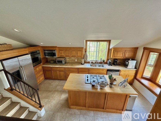 A kitchen with wooden cabinets and a stainless steel refrigerator.