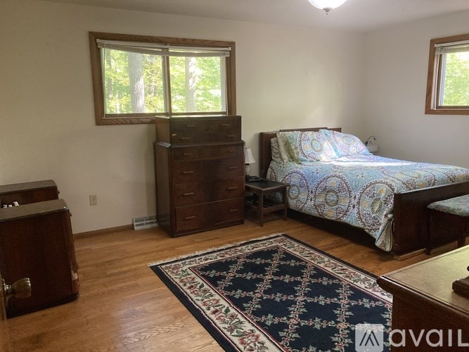A bedroom with a bed, dresser, and window.