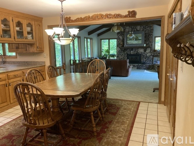 A dining room with a wooden table and chairs.