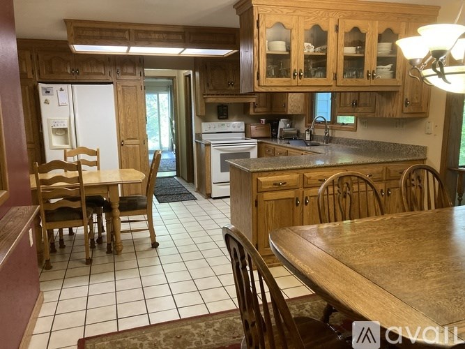 A kitchen with wooden cabinets and a dining table.