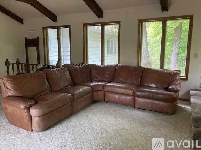 A brown leather sectional sofa in a living room.