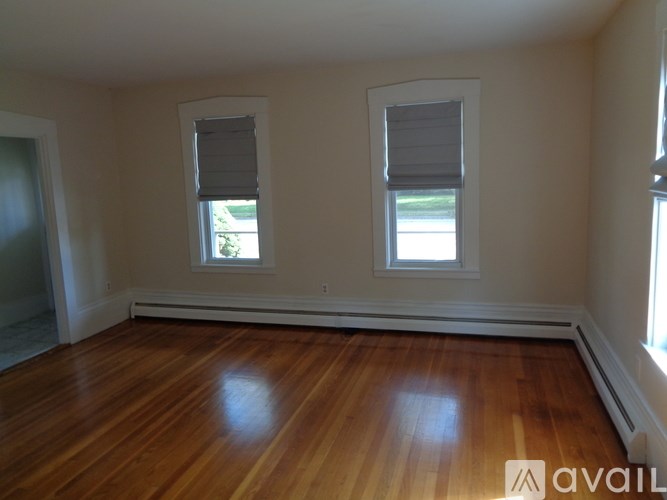A room with wooden floors and two windows.