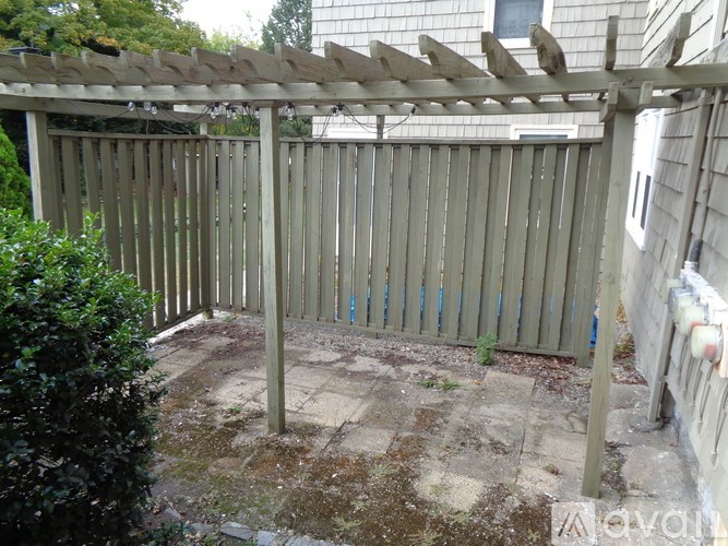 A wooden fence and pergola in a backyard.