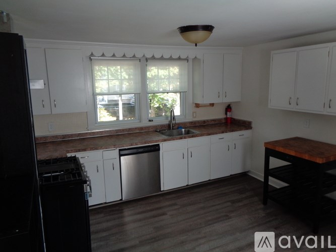 A kitchen with white cabinets and a wooden table.