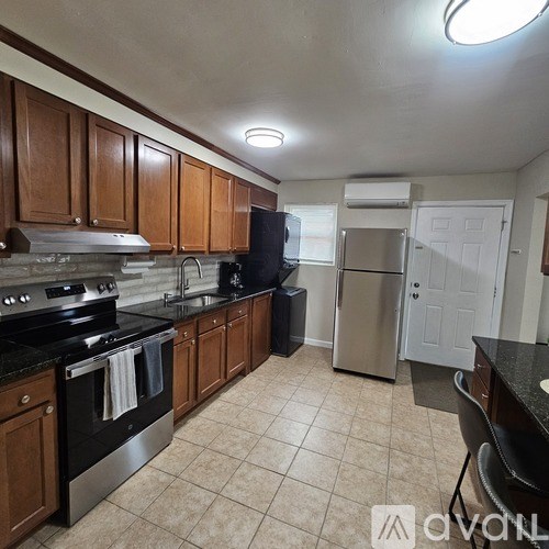 A kitchen with wooden cabinets and black appliances.
