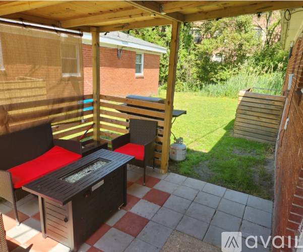 A patio with a grill and chairs.
