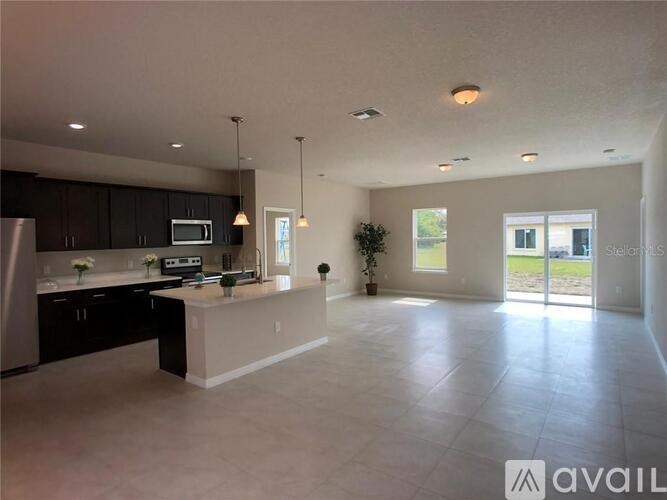 A spacious kitchen with dark cabinets and a central island.