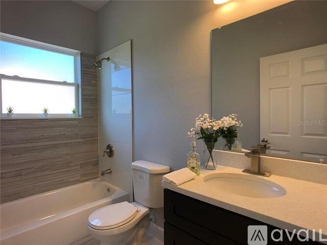 A bathroom with a white toilet, a bathtub, and a sink.