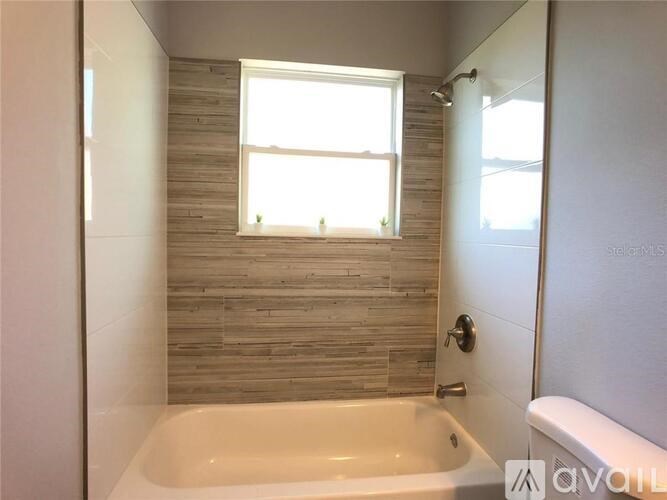 A bathroom with a tub and a window.
