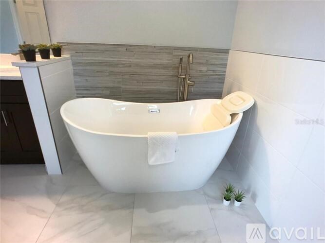 A white bathtub with a towel on it is in a bathroom.