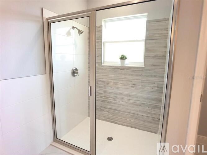 A bathroom with a glass door shower enclosure.