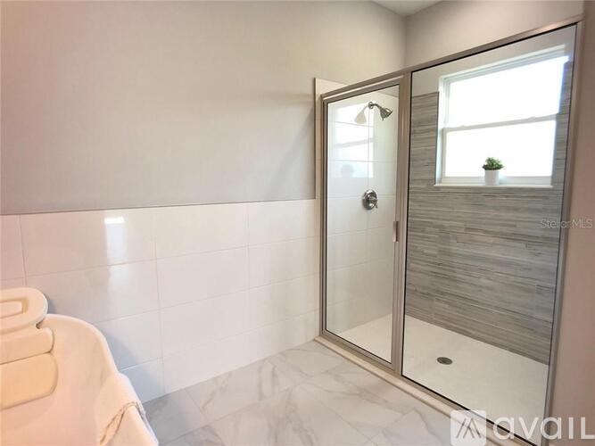 A white bathroom with a glass door shower.